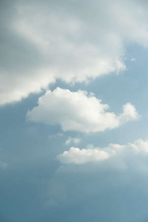 The white clouds have a quaint and rural shape. The sky is cloudy and blue.の写真素材