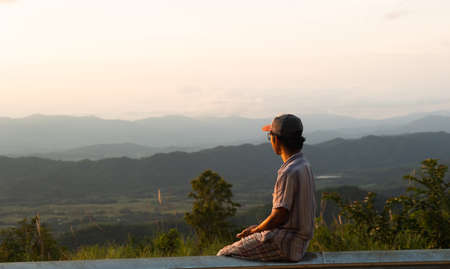 man sitting watching the scenery of the ridge line.copy space.man sitting and looking at natureの写真素材