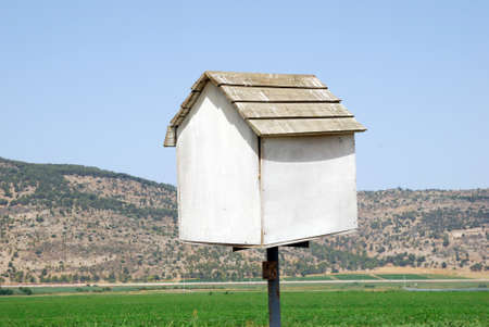 Bird house white on a background of brown mountains