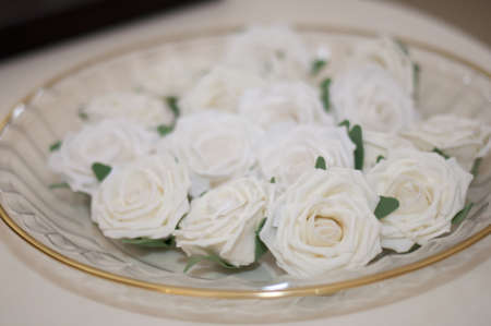 White roses on a transparent plate on the tableの写真素材