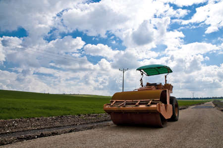 orange tractor on a background of grass and skyの写真素材