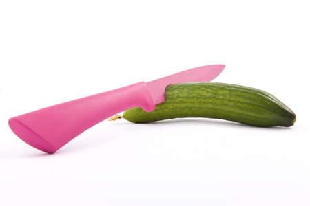 orange knife in the cucumber on a white backgroundの写真素材
