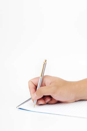 A hand holding a pen to write on a notepad isolated with white backgroundの写真素材