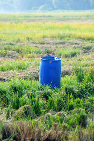 Blue tank for clear water in the middle of paddy field isolated green paddy fieldの写真素材