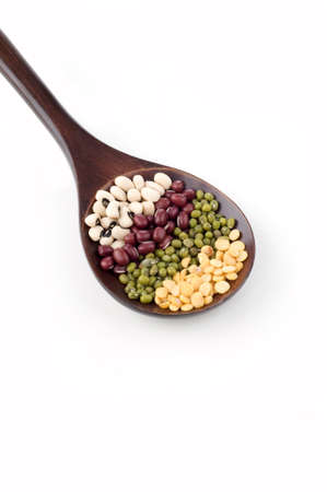dry legumes on brown spoon isolated white backgroundの写真素材
