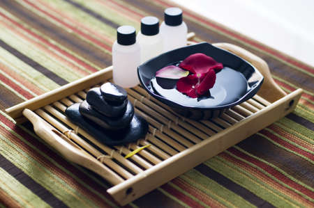 Set of black volcano rock ppreparation on bamboo tray isolated colorful cotton matの写真素材