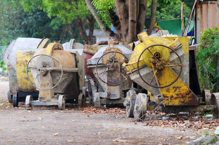 Used portable concrete mixer in row left behind the factoryのeditorial素材