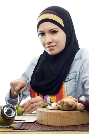 Beautiful muslim woman cutting limes in the kitchen prepare for cooking isolated white backgroundの写真素材
