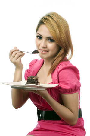 Beautiful young asian woman eating cake isolated white backgroundの写真素材