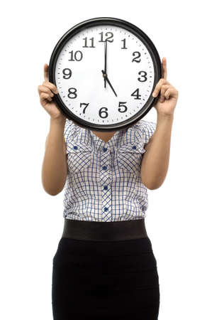 Beautiful young asian woman hold a clock cover her face show time at five o clock isolated white backgroundの写真素材