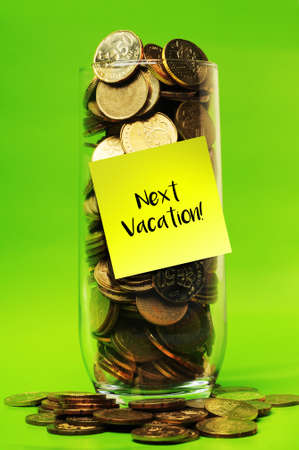 Overload coins in glass with sticky notes next vacationの写真素材