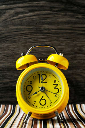 Yellow retro alarm clock on color mat shows 8 oclockの写真素材