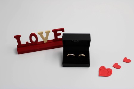 Golden wedding rings in black box and red harts