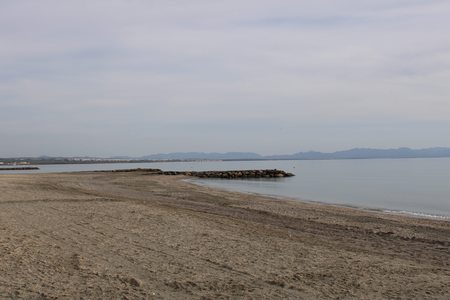 Beach on the coast of Spain with building and mountain backgroundの写真素材