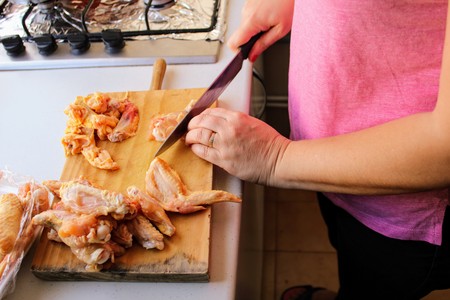 Cook preparing chicken meat on wooden boardの写真素材