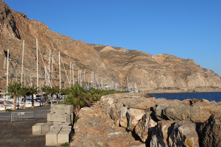 Stone pier in the marina at the foot of the mountainの写真素材
