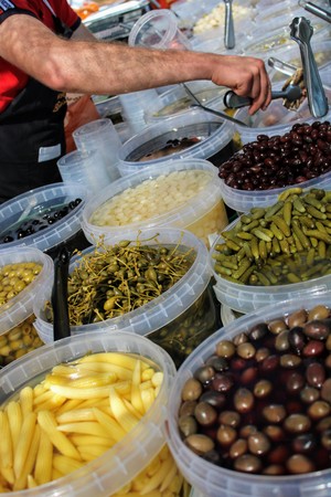 Buckets full of green and black olives , pickles and baby corn all pickled to mediterranean styleの写真素材