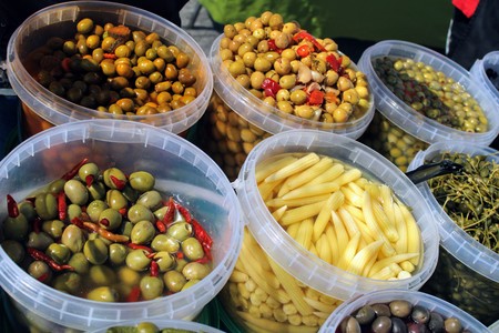 Buckets full of green and black olives , pickles and baby corn all pickled to mediterranean styleの写真素材