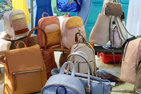 Shelf with leather bags and backpacks in different shades