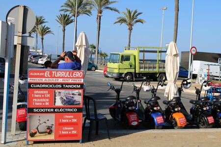 Place of leisure with tandem quadricycles and electric scooter in the Urbanization of Roquetas de Mar of AlmerÃ­a in Spain on july 14, 2019のeditorial素材