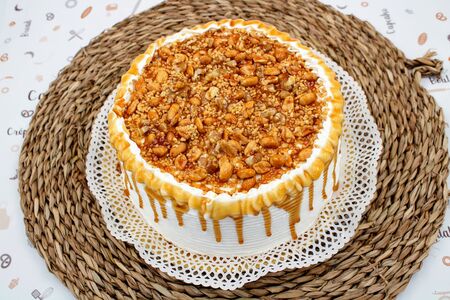 Cream cake with caramel syrup decoration and crispy peanutsの写真素材
