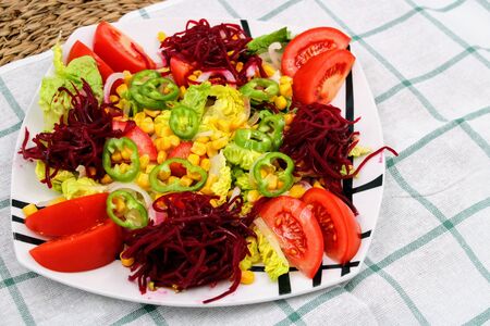 Colorful fresh vegetable salad with tomatoes , peppers , corn and lettuceの写真素材