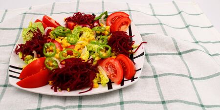 Colorful fresh vegetable salad with tomatoes , peppers , corn and lettuceの写真素材