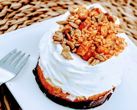 Sponge cake with chocolate base , whipped cream and toasted seedsの写真素材