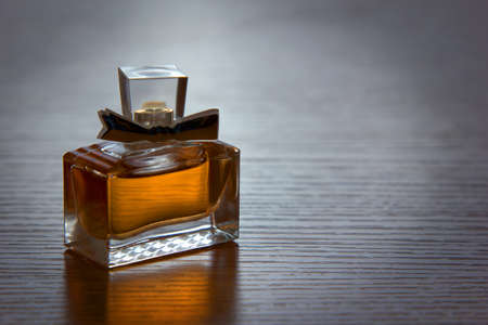 is square with women's perfume bottle on a dark backgroundの写真素材