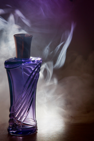 beautiful purple bottle female perfume in the smokeの写真素材
