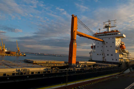 Sea going dry-cargo freighter is in the foreground  The hiab cranes are in the background 