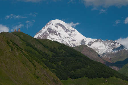 Mount Kazbek is one the highest peak in the Caucasus Mountains  The Gergeti Trinity Church is the main cultural landmark of Kazbegi District, Georgia の写真素材