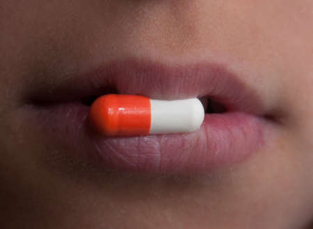 This is a close-up of  pill  Somebody keeps a pill in the lips  の写真素材