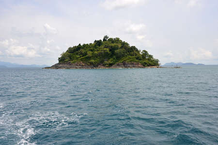 Green island is surrounded with blue sea. This is a lush tropical island (Thailand).