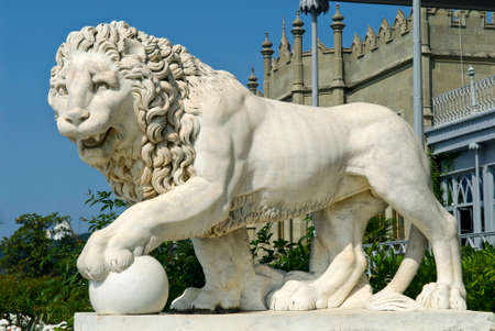 This marble lion sculpture is situated in Vorontsov Palace - Alupka, Crimea. The lion and palace are situated against the blue sky background.のeditorial素材