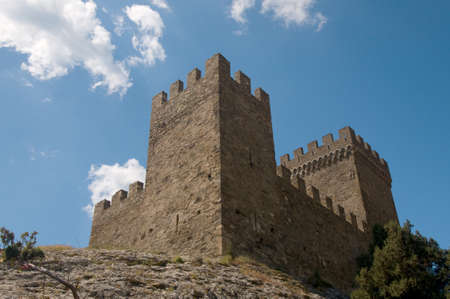 The tower of a Genoese fortress is situated on the rock against the blue sky background. This is a Genoese Sudak Castle, Crimea.のeditorial素材