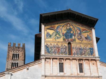 The Basilica di San Frediano in Lucca is a medieval basilica with large campanile and a 13th-century mosaics on its facade. The church is situated against the blue sky background.のeditorial素材