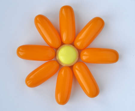 Bright pills are situated on the white background. Composition Flower is created from medical ...