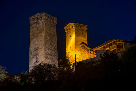 Illuminated traditional svan towers against night sky background. Place - Mestia highland townlet,...