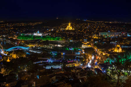 Tbilisi. The photo of illuminated Cathedral and presidential palace is taken against the night cityscape background. The Holy Trinity Cathedral of Tbilisi is the main Cathedral of the Georgian Orthodox Church located in Tbilisi, the capital of Georgia.の写真素材