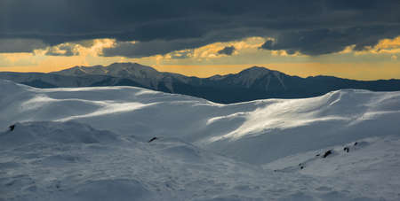 Carpathian mountains at sunset in winter season. Slightly sloping range in foreground is Ukrainian...