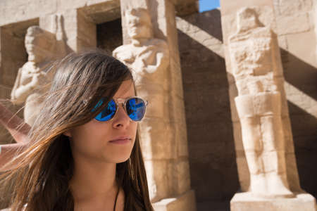 Girl with sunglasses against Luxor architecture background. Landmarks of Egypt.の写真素材