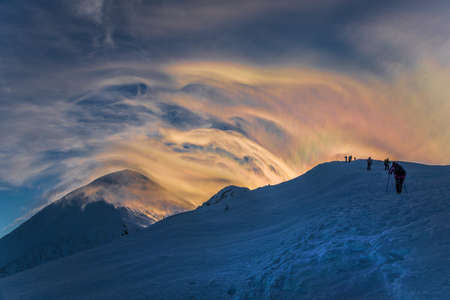 Winter hill climbing to Goverla Mount. Tourists are moving along mount range. Beautiful sky with clouds in background.の写真素材