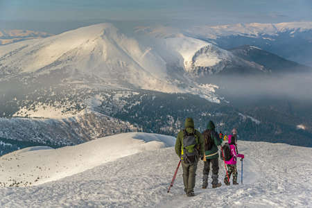Tourist group descent of the mountain in winter season. Mount Petros is in background.