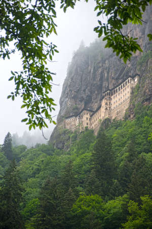 Sumela  monastery in the cliff and bright green trees in foreground.の写真素材