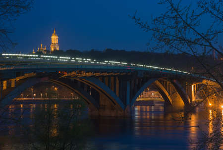 Kiev. Illuminated Metro Bridge and Kiev Pechersk Lavra at evening time.の写真素材