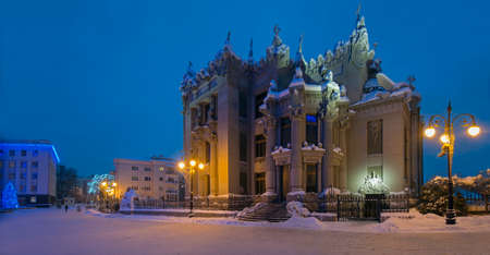Illuminated House with Chimaeras or Horodecki House. Evening scene. Building and street are powdered with snow.のeditorial素材