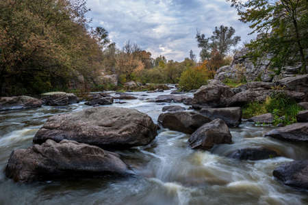 Mountain stream surrounded with autumn trees.の写真素材