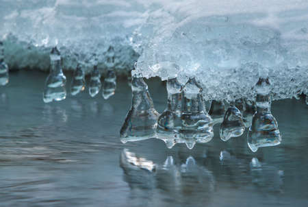 Ice formations under stream. Close-up.
