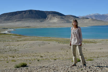 Woman near blue mountain lake. Place - Pamir.の写真素材